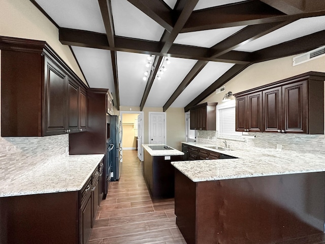 kitchen with kitchen peninsula, decorative backsplash, sink, dark brown cabinetry, and light stone counters