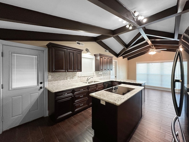 kitchen featuring black appliances, vaulted ceiling with beams, tasteful backsplash, sink, and kitchen peninsula