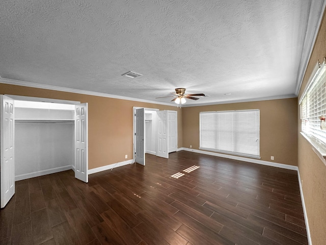 unfurnished bedroom with a textured ceiling, ceiling fan, ornamental molding, and dark hardwood / wood-style floors