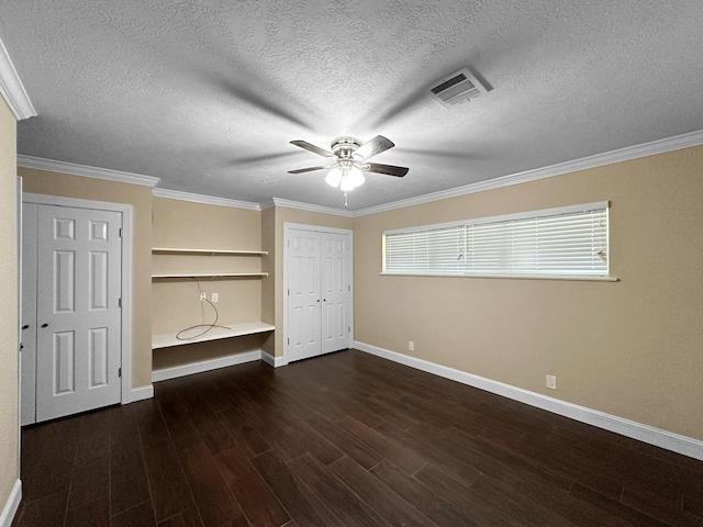 unfurnished bedroom with ceiling fan, a textured ceiling, dark hardwood / wood-style floors, and ornamental molding