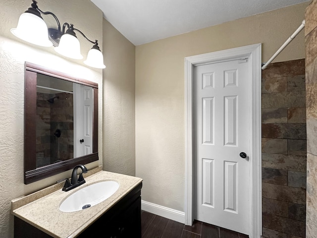 bathroom featuring a shower and vanity