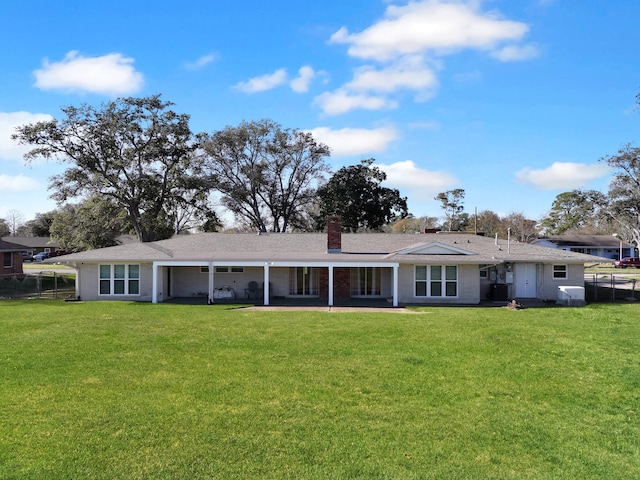 rear view of property with a lawn and central air condition unit