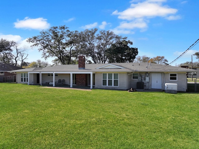 back of house with a patio, a lawn, and central AC