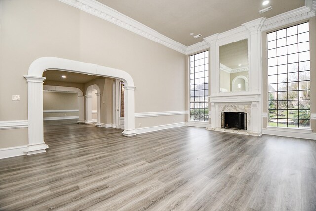 unfurnished living room with a premium fireplace, ornamental molding, and hardwood / wood-style flooring