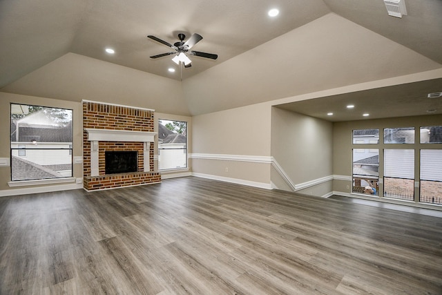 unfurnished living room featuring hardwood / wood-style flooring, vaulted ceiling, ceiling fan, and a fireplace