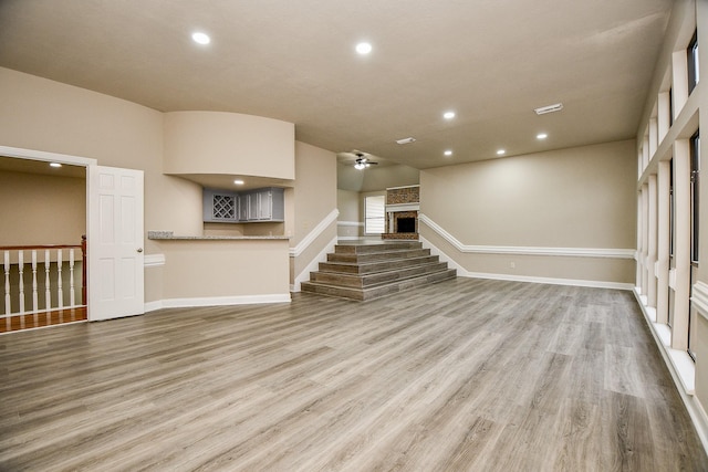 unfurnished living room featuring a brick fireplace and light hardwood / wood-style floors