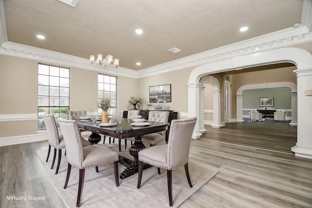 dining room with crown molding, an inviting chandelier, and hardwood / wood-style flooring