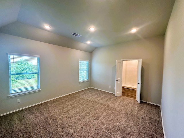 carpeted empty room featuring lofted ceiling