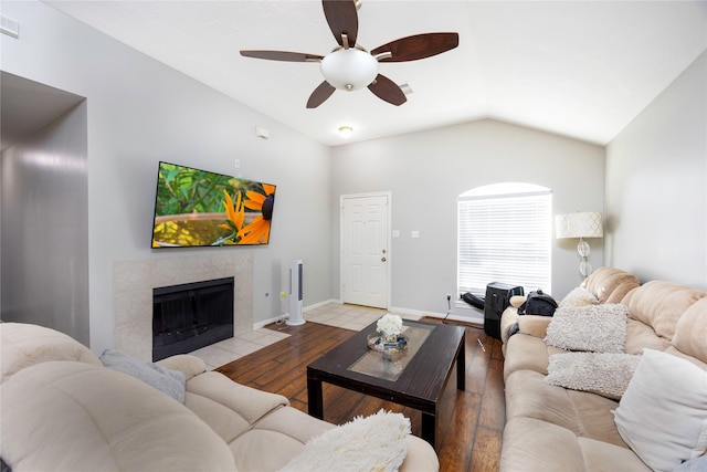 living room featuring light wood-type flooring, ceiling fan, lofted ceiling, and a fireplace