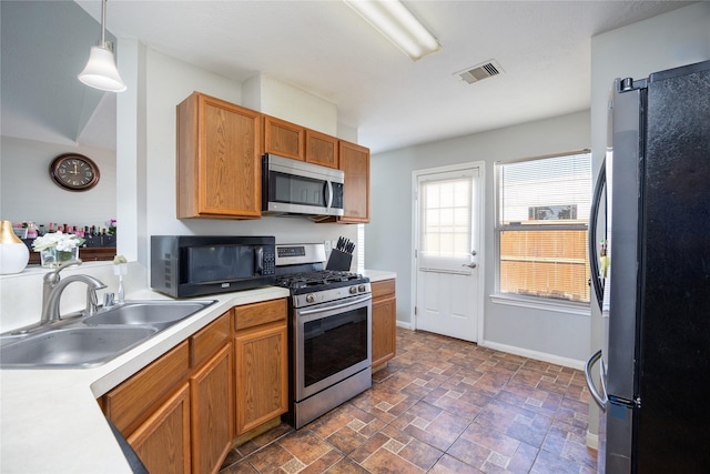 kitchen with decorative light fixtures, sink, and appliances with stainless steel finishes