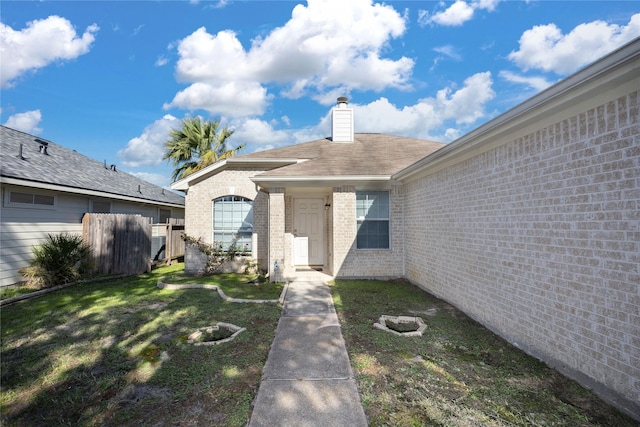 view of exterior entry with a lawn