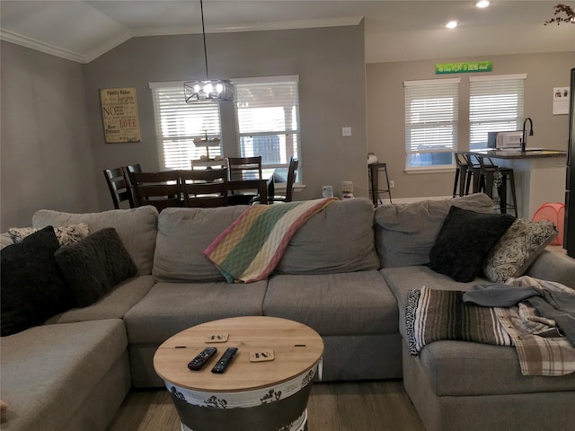 living room with hardwood / wood-style floors, ornamental molding, lofted ceiling, and a wealth of natural light