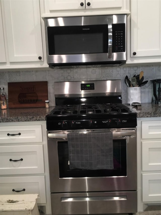 kitchen featuring backsplash, appliances with stainless steel finishes, and white cabinets