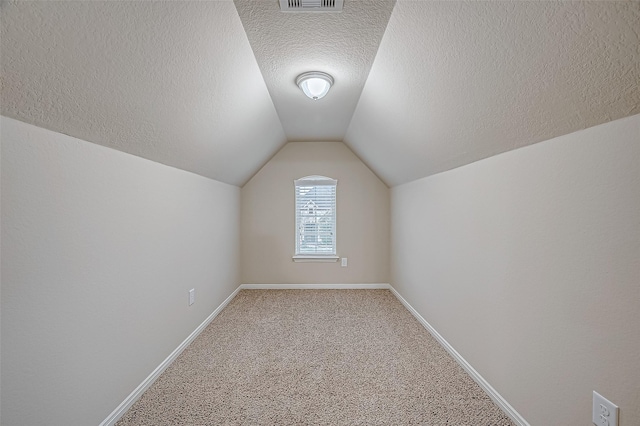 bonus room featuring a textured ceiling, vaulted ceiling, and carpet flooring