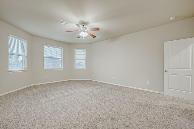 carpeted spare room featuring ceiling fan