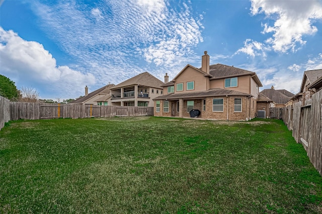 rear view of house with a lawn and central AC unit