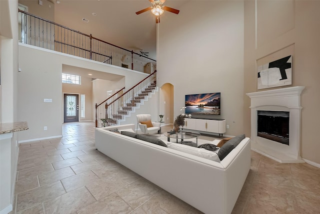 living room with a high ceiling, ceiling fan, and french doors