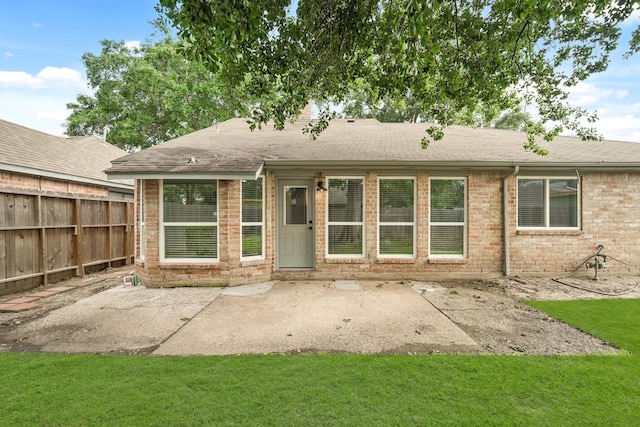 rear view of house featuring a lawn and a patio area