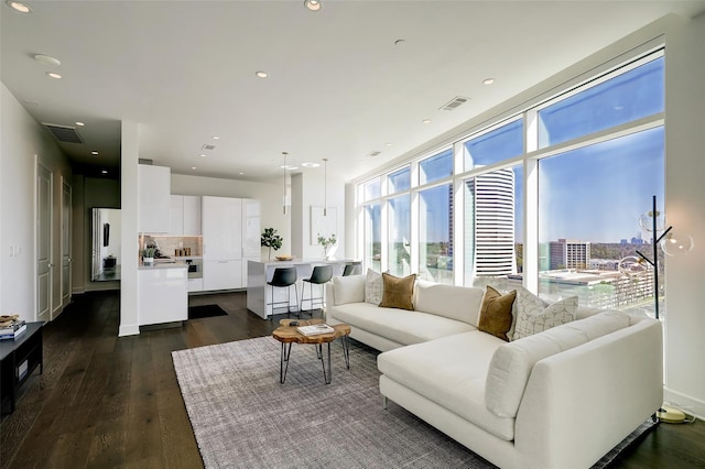 living room featuring dark wood-type flooring and a wall of windows