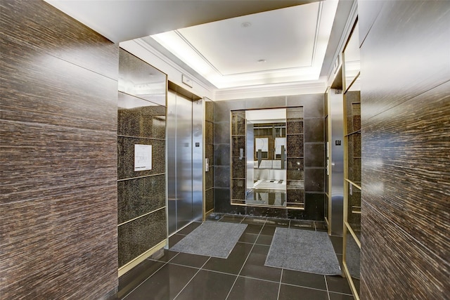 bathroom with tile walls, tile patterned flooring, and a tray ceiling