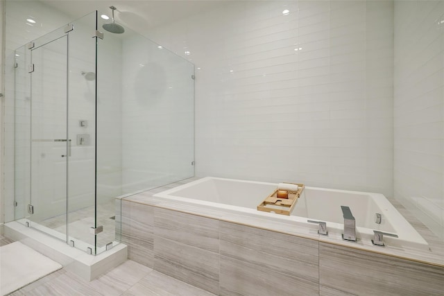 bathroom featuring shower with separate bathtub