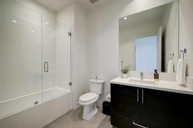 full bathroom with combined bath / shower with glass door, tile patterned flooring, vanity, and toilet