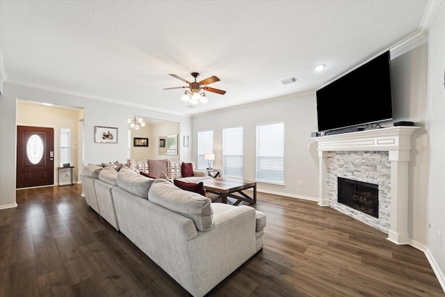 living room featuring a stone fireplace, crown molding, dark hardwood / wood-style flooring, a textured ceiling, and ceiling fan with notable chandelier