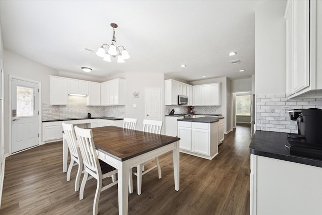 dining room featuring dark wood-type flooring and an inviting chandelier