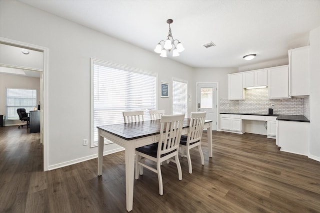 dining area with an inviting chandelier and dark hardwood / wood-style floors