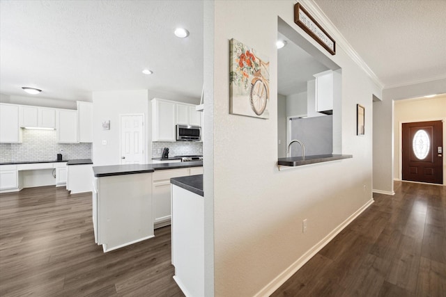 kitchen featuring white cabinets, stainless steel appliances, dark hardwood / wood-style flooring, and decorative backsplash