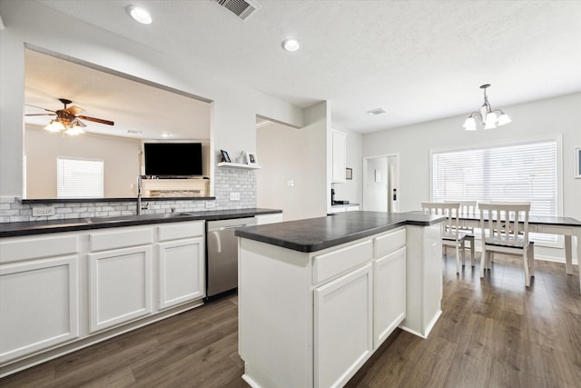 kitchen featuring dishwasher, decorative light fixtures, decorative backsplash, white cabinetry, and sink