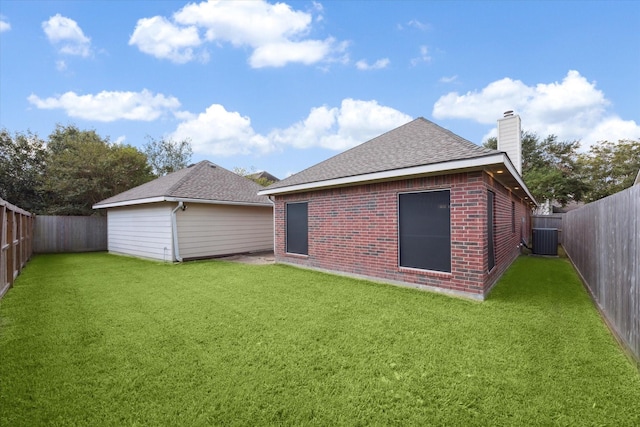 back of house with central AC and a lawn