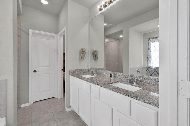 bathroom featuring tile patterned floors, a shower with door, and vanity