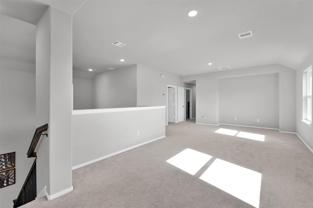 carpeted spare room with vaulted ceiling