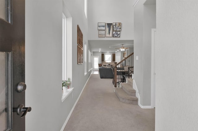 corridor featuring a towering ceiling and carpet flooring