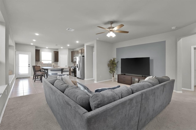 carpeted living room with ceiling fan