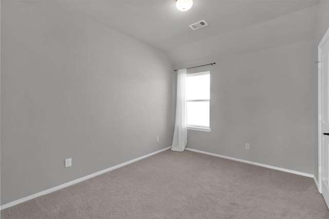 carpeted empty room with vaulted ceiling