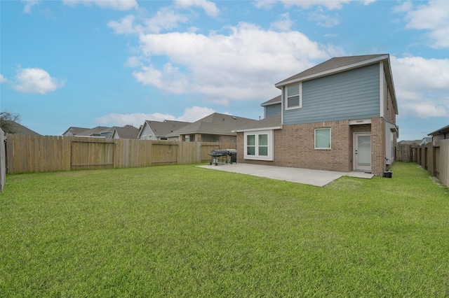 rear view of house with a lawn and a patio