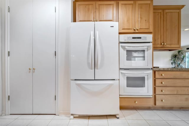 kitchen featuring white appliances and light tile patterned flooring