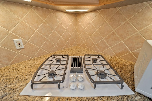 room details with white gas stovetop and stone counters