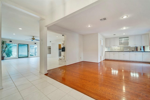 unfurnished living room with ceiling fan and light tile patterned flooring