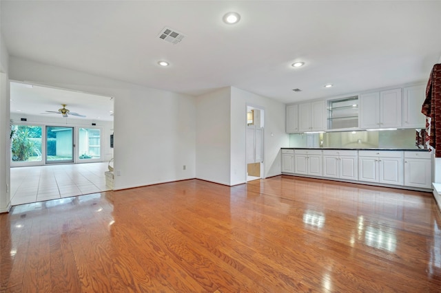 unfurnished living room with ceiling fan and light wood-type flooring