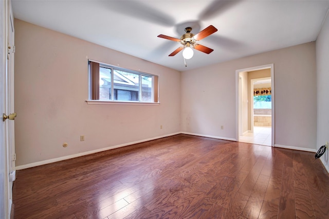 empty room featuring dark wood-type flooring and ceiling fan