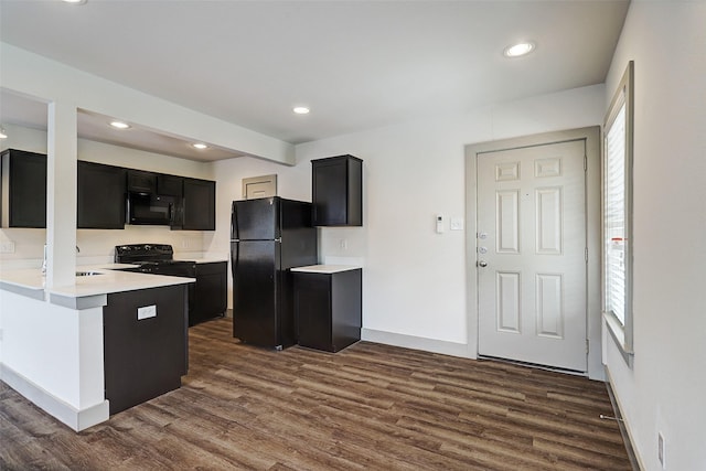 kitchen with black appliances, sink, and dark hardwood / wood-style floors