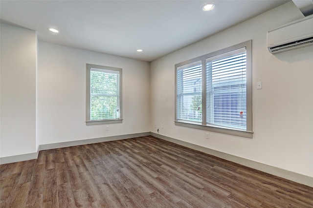 spare room with dark hardwood / wood-style flooring and a wall mounted AC