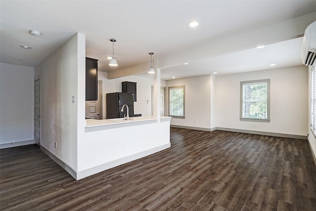 kitchen with sink, black fridge, dark hardwood / wood-style flooring, and pendant lighting