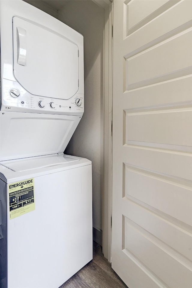 laundry area featuring stacked washer and dryer and dark hardwood / wood-style floors