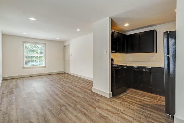 kitchen with black appliances and light hardwood / wood-style flooring