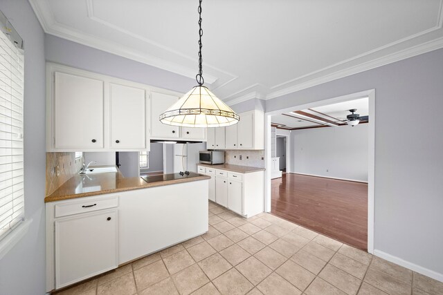 kitchen featuring backsplash, black electric stovetop, light tile patterned flooring, and white cabinets