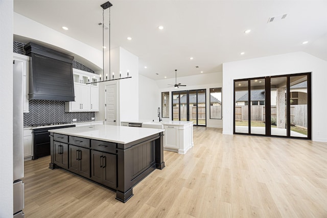 kitchen with a healthy amount of sunlight, pendant lighting, white cabinetry, and ceiling fan